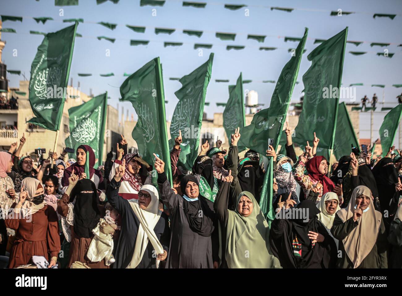 Gaza, Palestine. 29th May, 2021. Palestinian women chant with flags during an anti-Israel military parade by Izz al-Din al-Qassam Brigades in Rafah, in the southern Gaza Strip. Credit: SOPA Images Limited/Alamy Live News Stock Photo