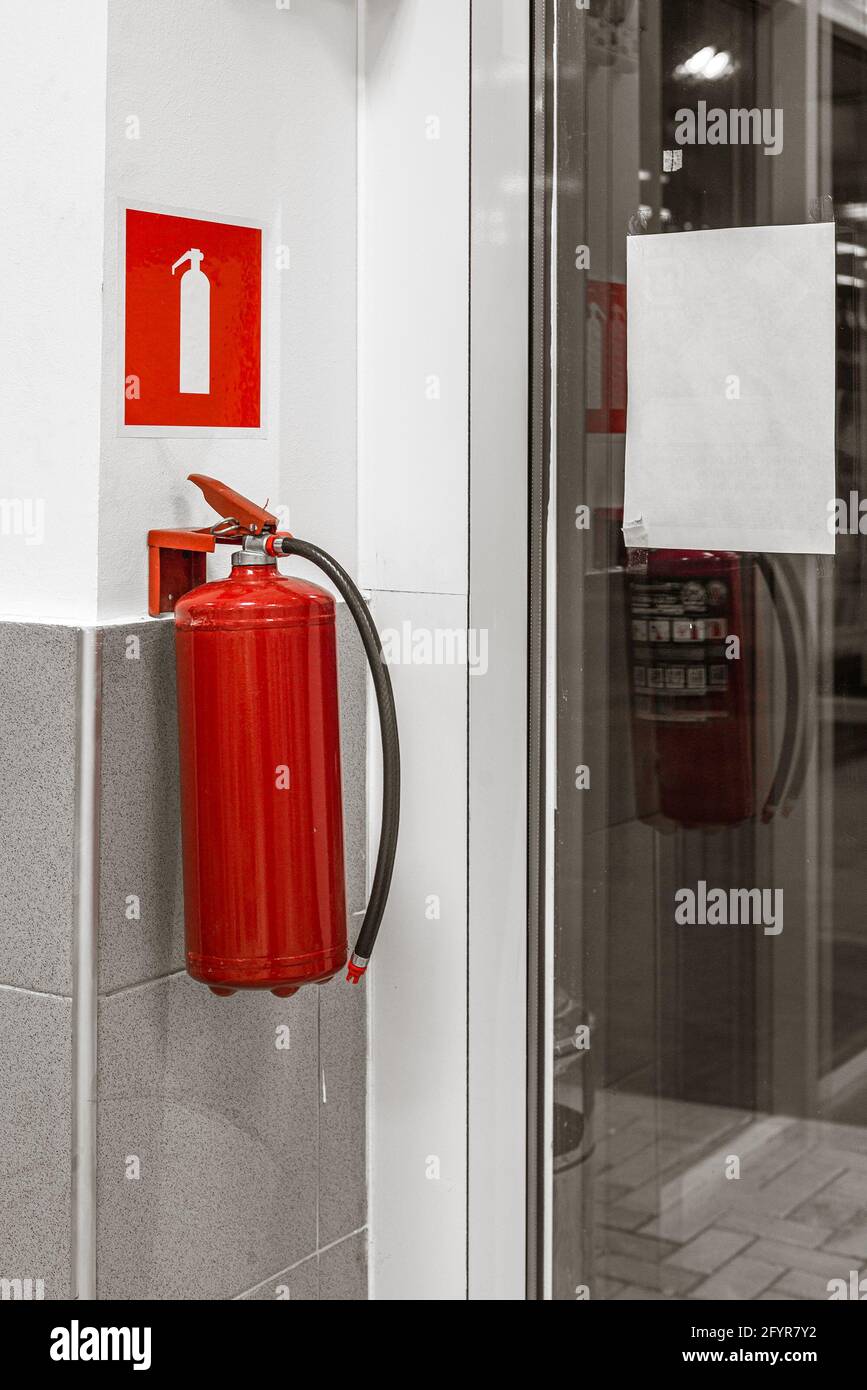 fire extinguisher and sign on wall Stock Photo