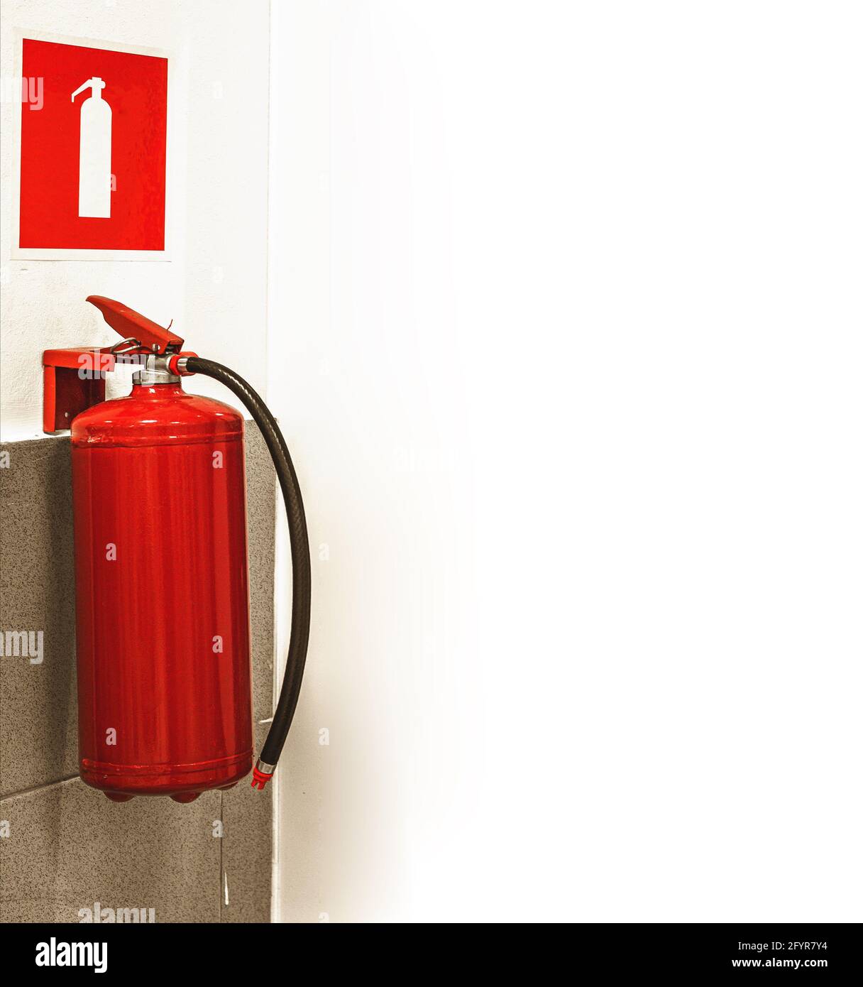 fire extinguisher and sign on white wall Stock Photo