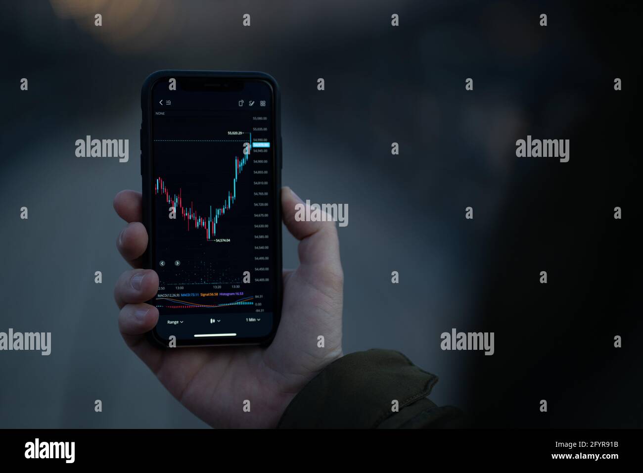 Male hand holding smartphone with real time forex chart on screen Stock Photo