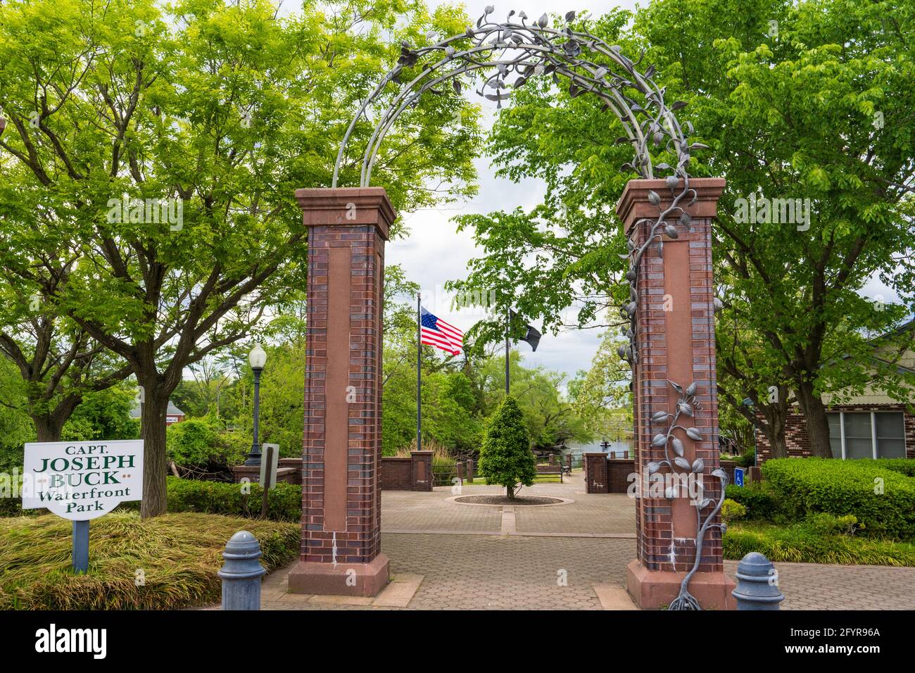 Millville, NJ - May 11, 2021: Entrance to Captain Joseph Buck Waterfront park with brick arch and metal leaf sculpture Stock Photo