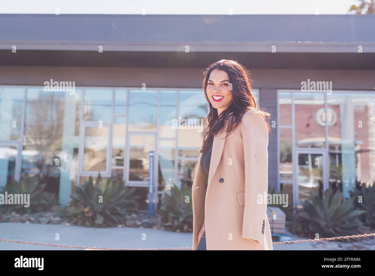 Business woman walking on the sidewalk with a big smile on her face. Stock Photo