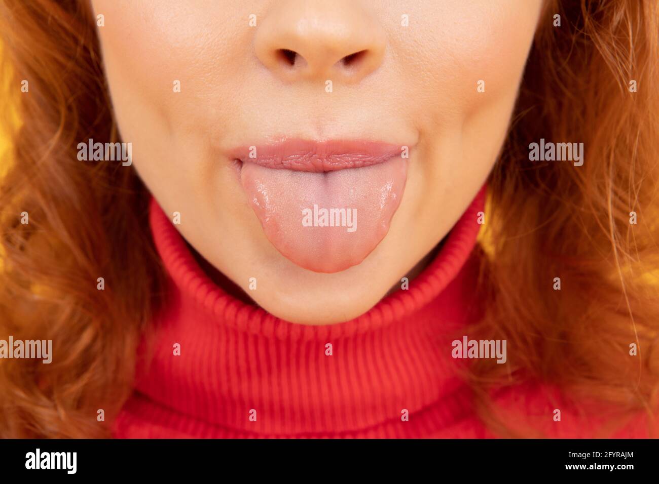 Sticking her tongue out. Woman cropped view stick clean tongue out of mouth Stock Photo Alamy