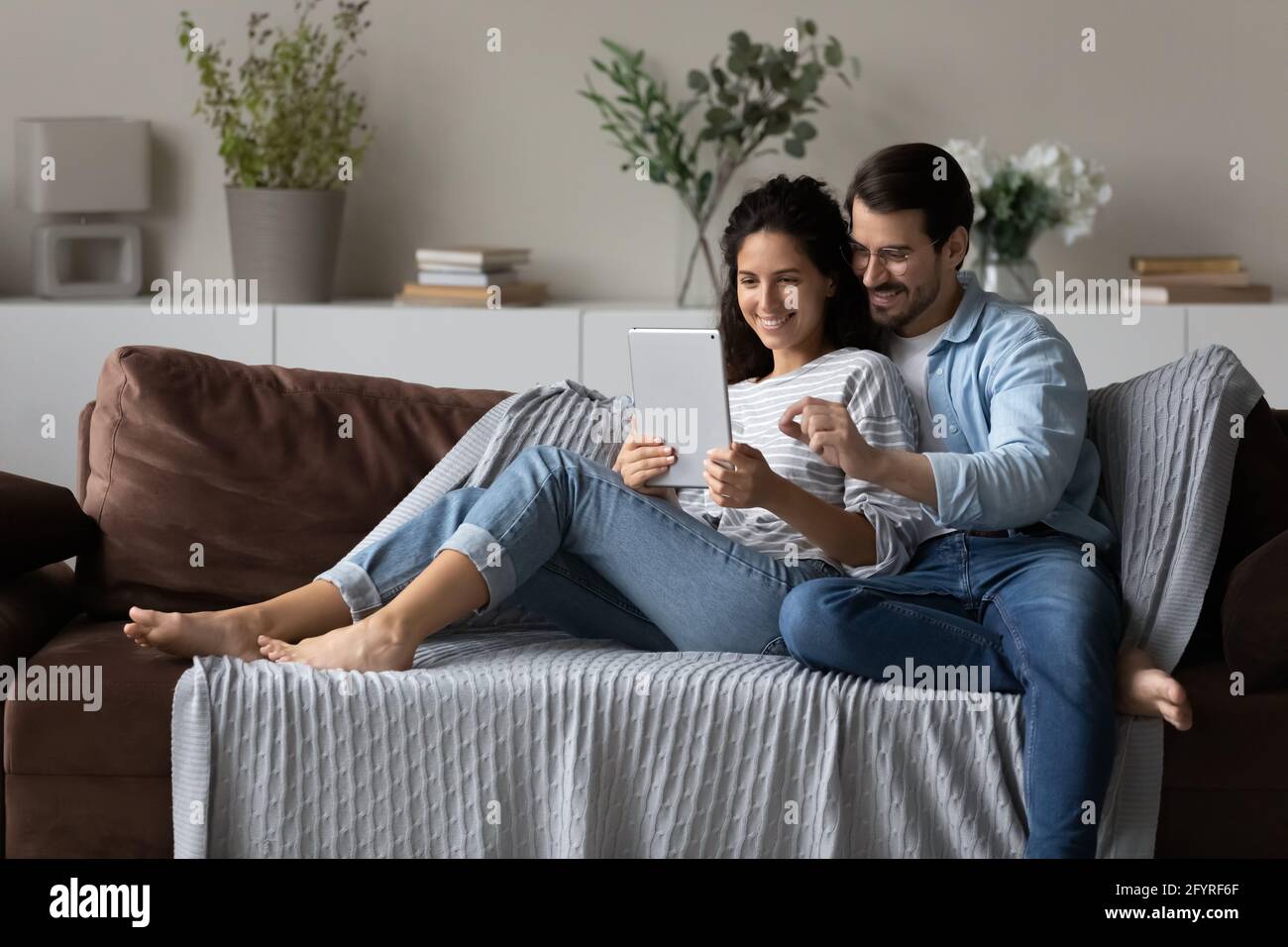 Smiling multiracial couple use tablet talking on video call Stock Photo