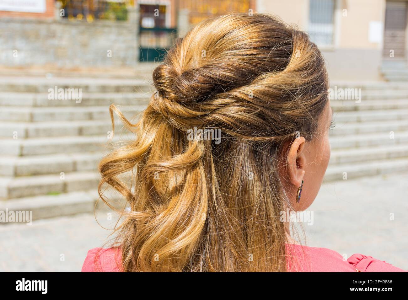 Detail of a half updo hairstyle. Young, blonde woman in a ceremony Stock Photo