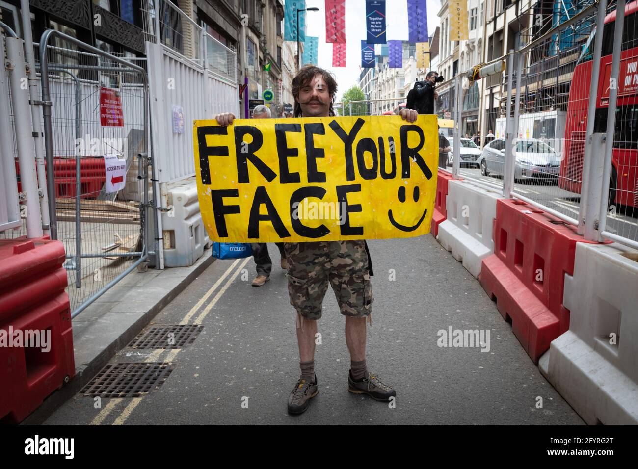 Manchester, UK. 29th May, 2021. A man with a placard stops during a anti-lockdown protest. The number of people attending the protests has increased month on month since the introduction of the COVID-19 restrictions. Credit: Andy Barton/Alamy Live News Stock Photo