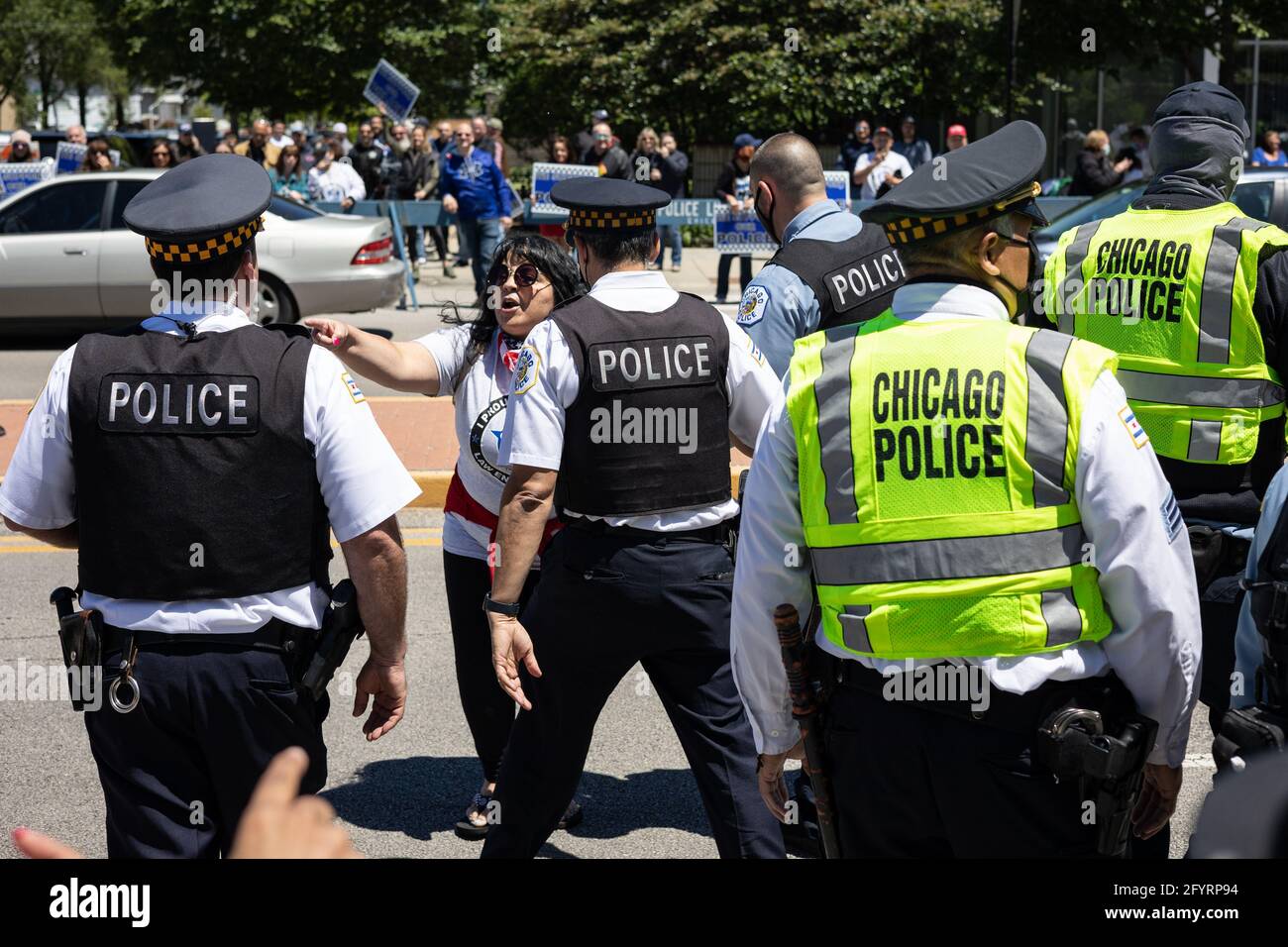 A pro police supporter taunting family members and supporters of Anthony  Alvarez is escorted across the street outside of the 16th District police  precinct in the Jefferson Park neighborhood in Chicago, Illinois