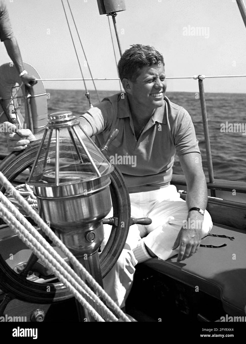 President John F. Kennedy sits aboard the United States Coast Guard boat Manitou in Narragansett Bay, Newport, Rhode Island. The President sailed on the yacht during his vacation at Hammersmith Farm in Newport. 26 August 1962. Stock Photo