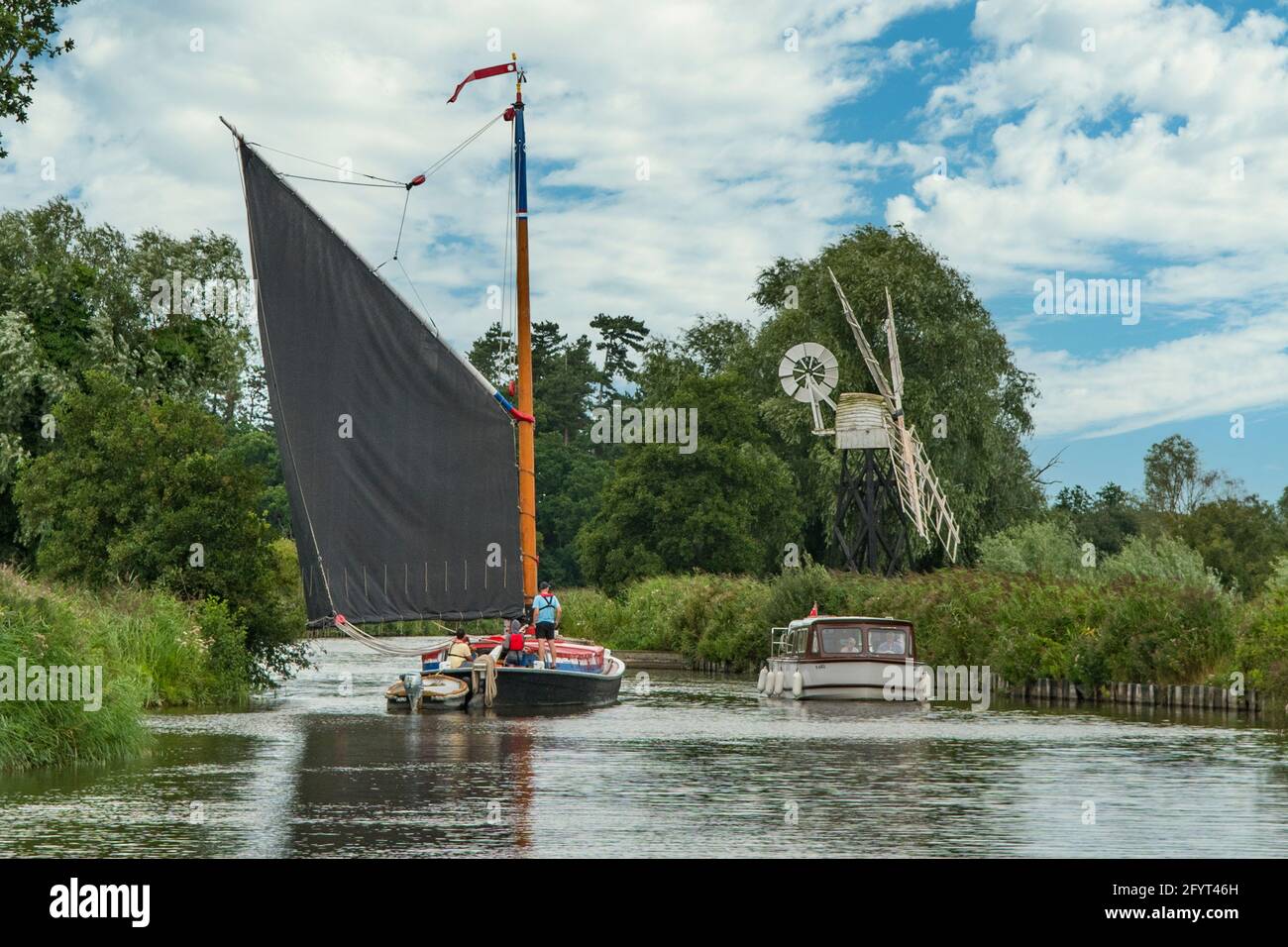 Sailboat on River Ant and Boardman's Mill, near Ludham, Norfolk, England Stock Photo