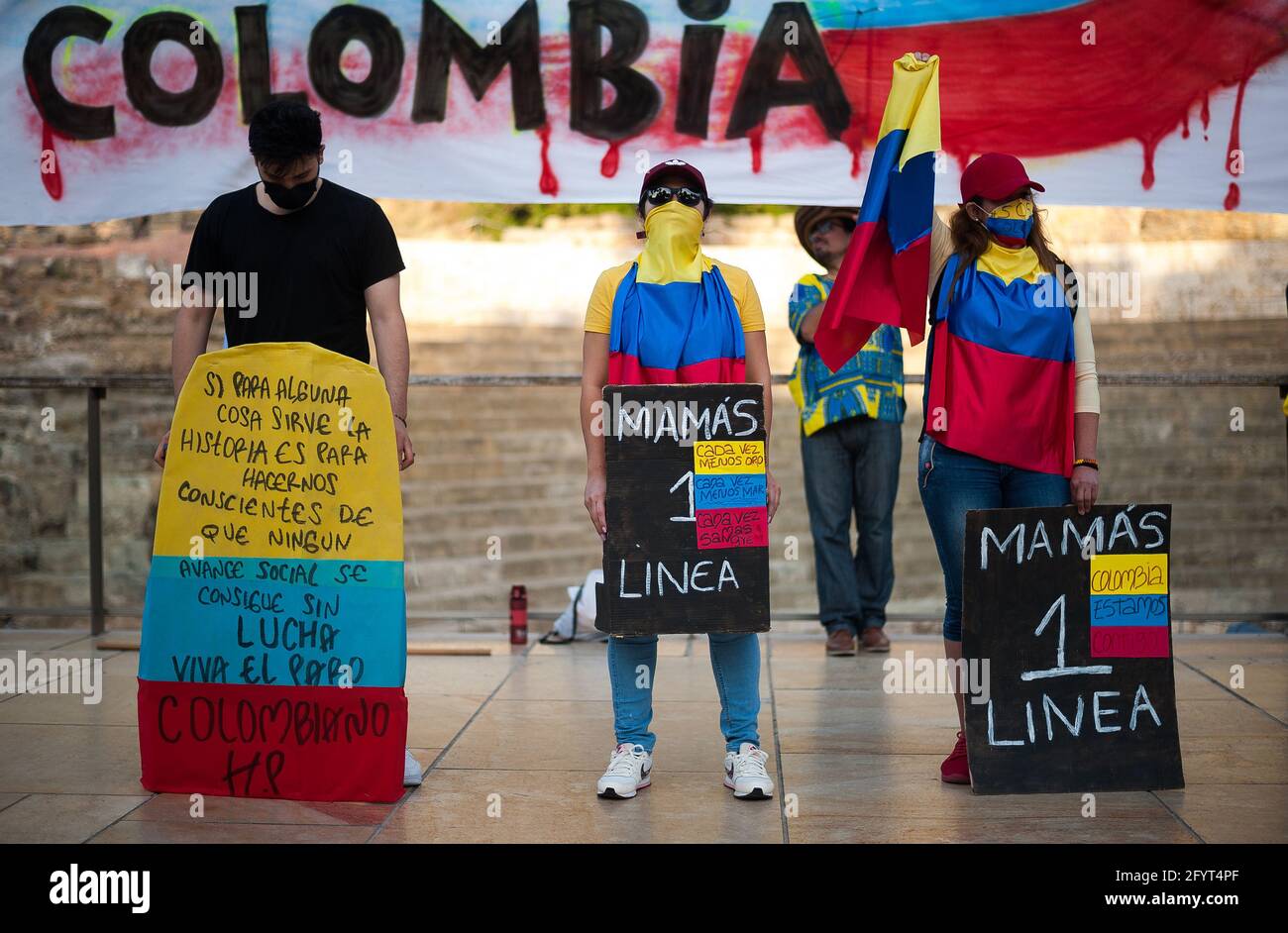 Malaga, Spain. 29th May, 2021. Colombian protesters wrapped with Colombian flags hold placards during a protest on Alcazabilla street.After a month of protests following the social burst in Colombia, dozens of Colombians living in Malaga showing again their solidarity with the Colombian population and against the violence of the government of President Iván Duque. Credit: SOPA Images Limited/Alamy Live News Stock Photo