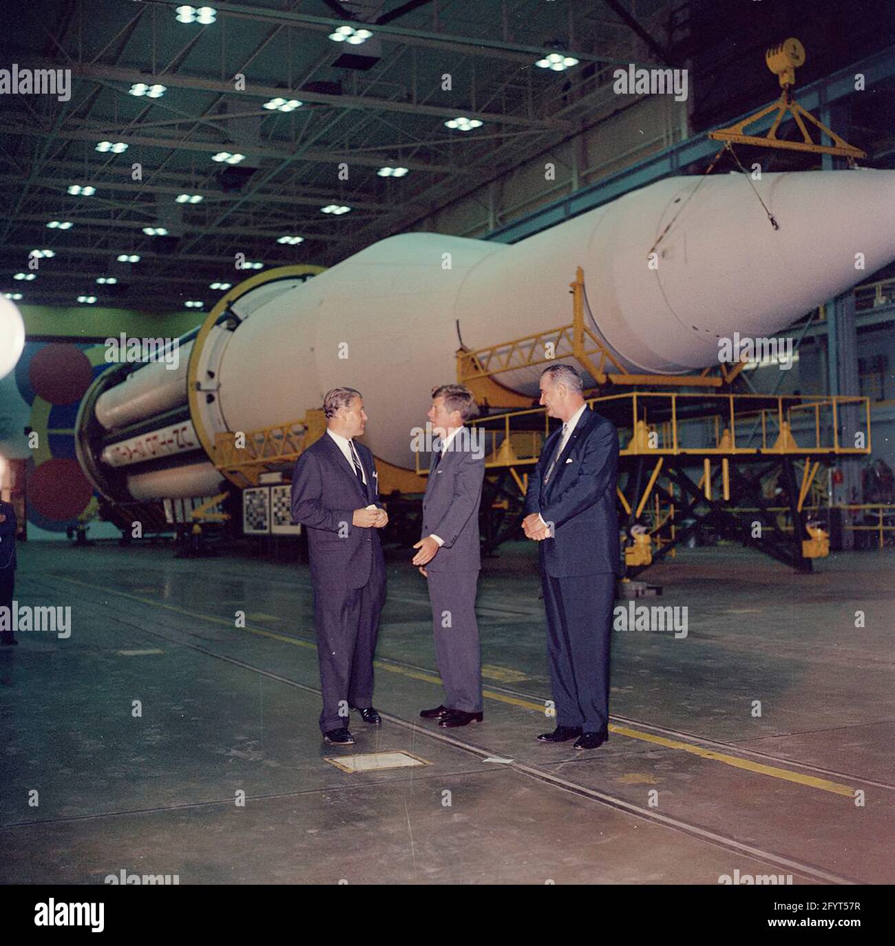 11 September 1962 Inspection tour of NASA installations: Huntsville Alabama, Redstone Army Airfield and George C. Marshall Space Flight Center, President John F. Kennedy speaks with Director of the George C. Marshall Space Flight Center (MSFC), Dr. Wernher von Braun (center left), during a tour of the MSFC at Redstone Arsenal, Huntsville, Alabama; Vice President Lyndon B. Johnson stands at right. The Saturn C-1 rocket sits in background. President Kennedy visited the MSFC as part of a two-day inspection tour of National Aeronautics and Space Administration (NASA) field installations. Stock Photo