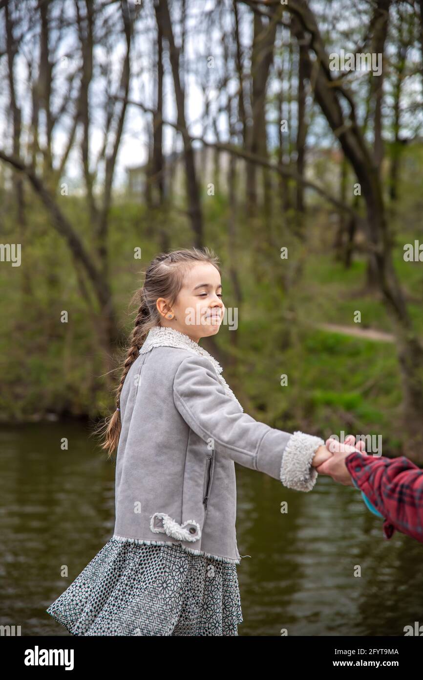A little girl walks with her dad in the forest and holds his hand Stock ...