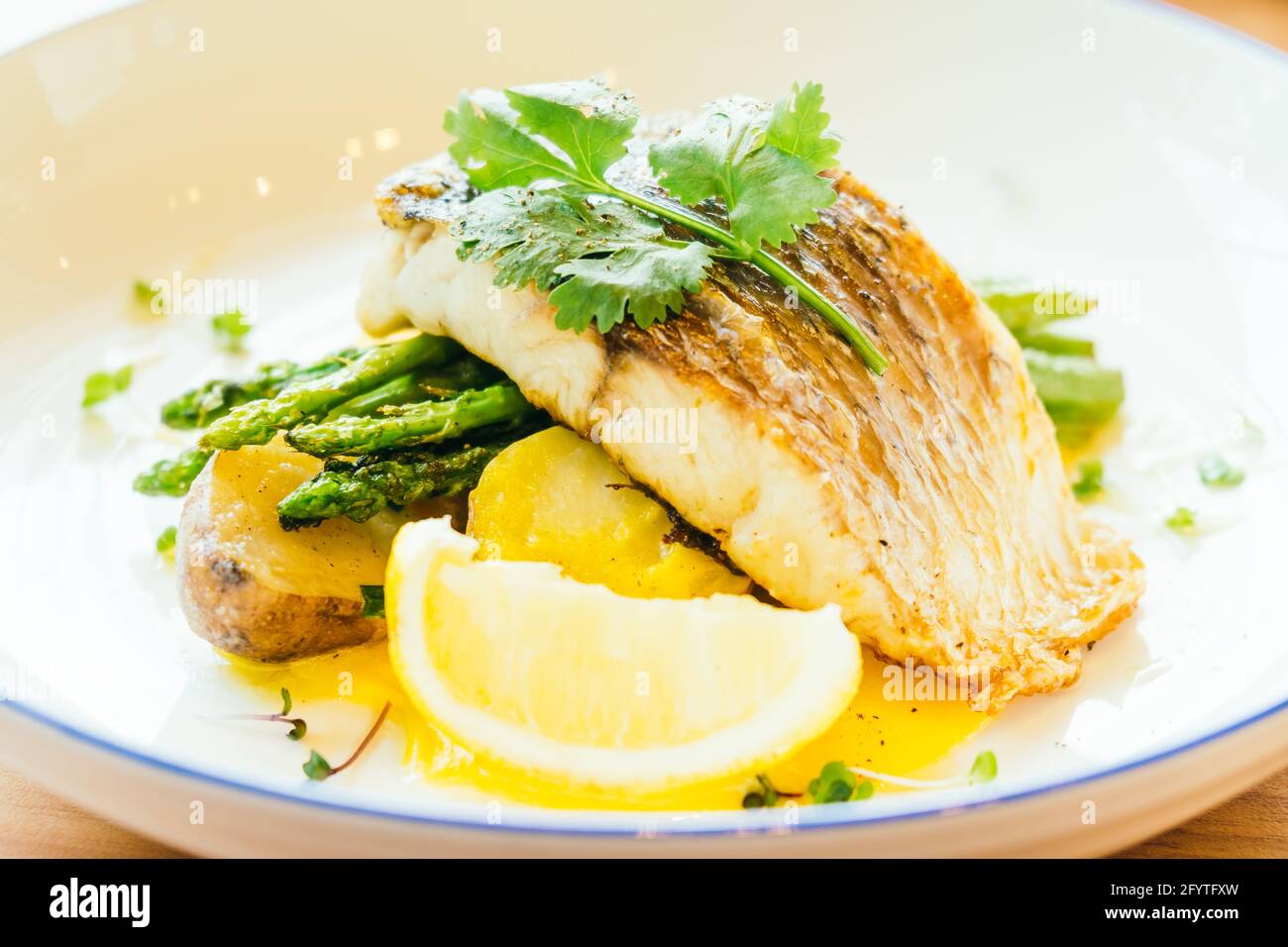Grilled Barramundi or pangasius fish and meat steak with vegetable and lemon in plate - Healthy food style Stock Photo