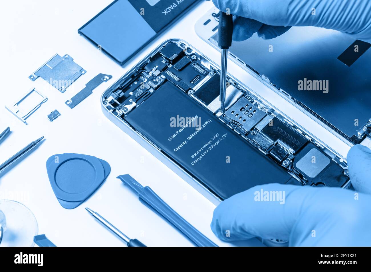 Professional occupation services concept - technician or engineer is repairing modern smartphone motherboard in the professional laboratory (blue tone Stock Photo