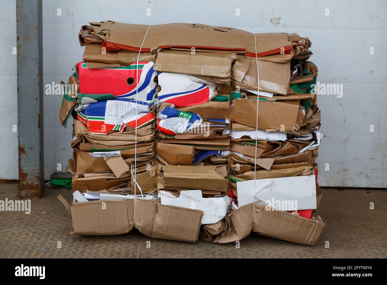 compressed cardboard waste bales compacted in a block behind grocery