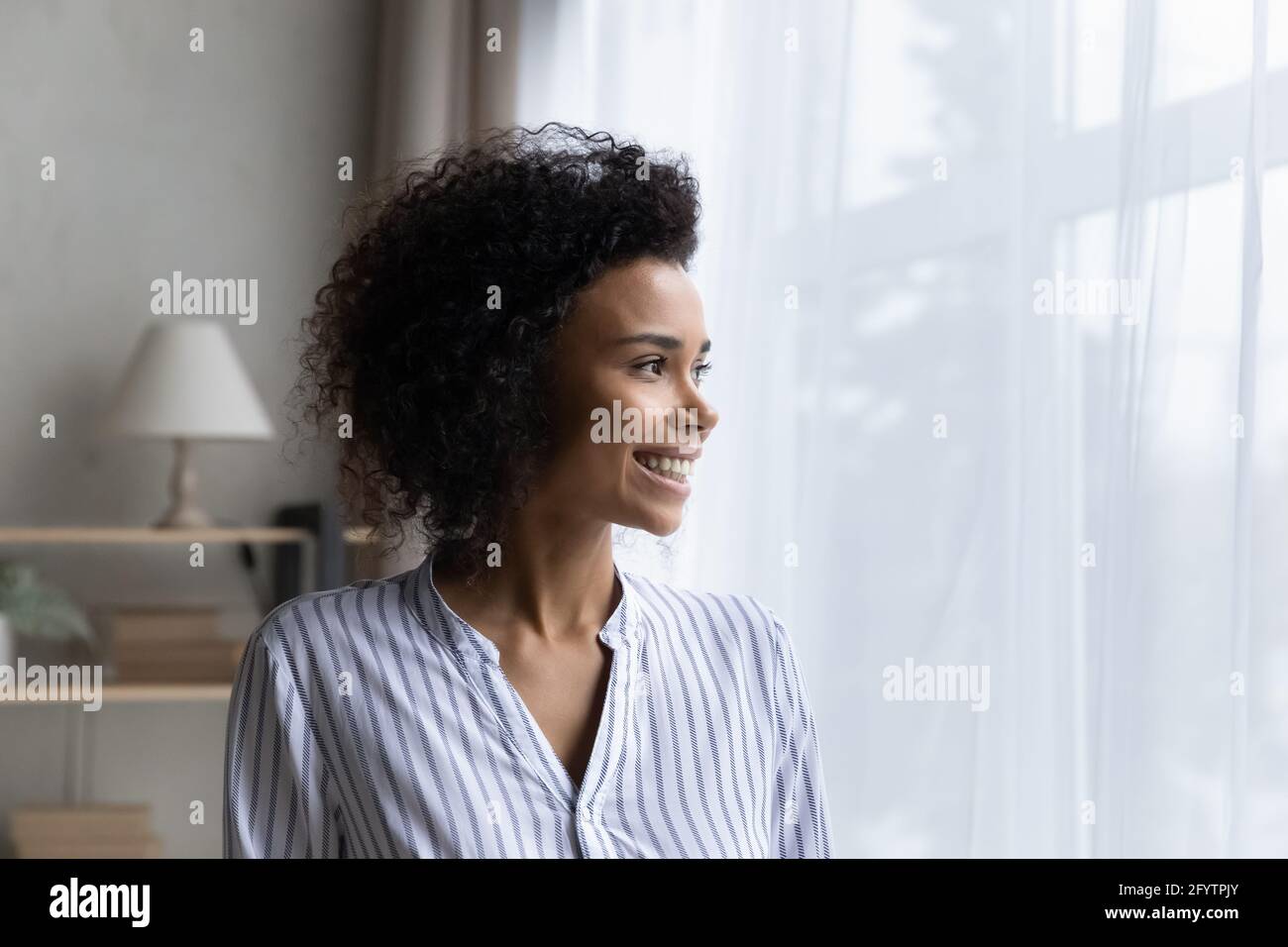 Smiling African American woman look in distance dreaming Stock Photo ...