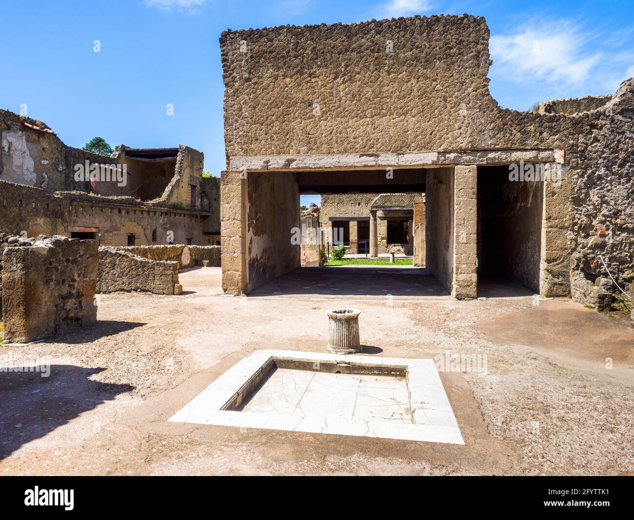 Rectangular atrium (main hall) with a marble lined impluvium (water tank) and a puteal with a fluted shaft made from a single block of white limestone House of the Black Hall (Casa del Salone Nero) - Herculaneum ruins, Italy Stock Photo