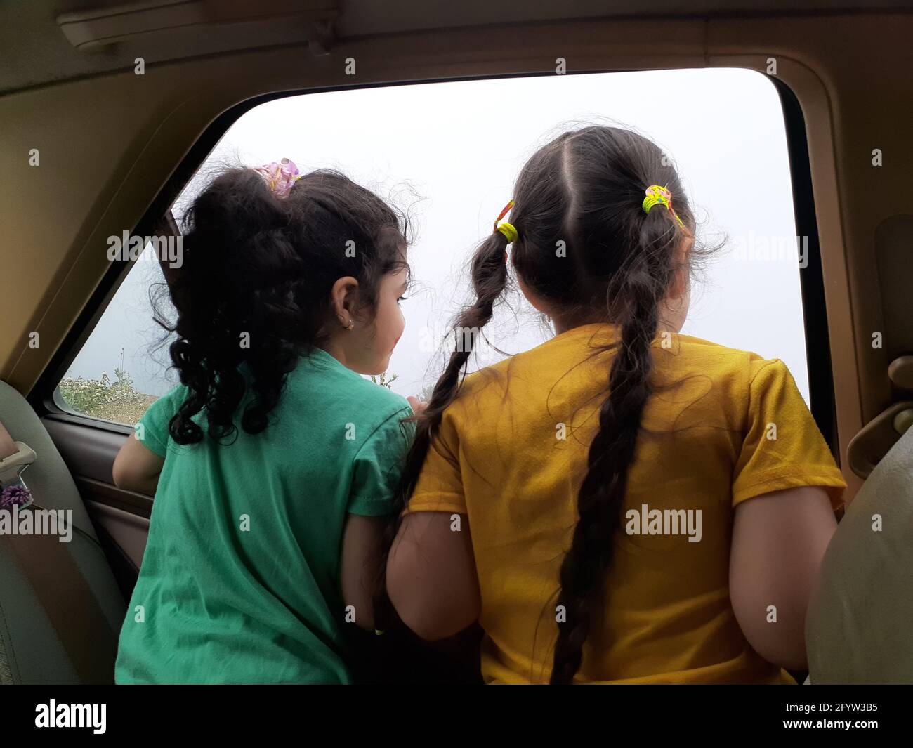 Back view of two little child girl looking outside of car-family travel concept Stock Photo