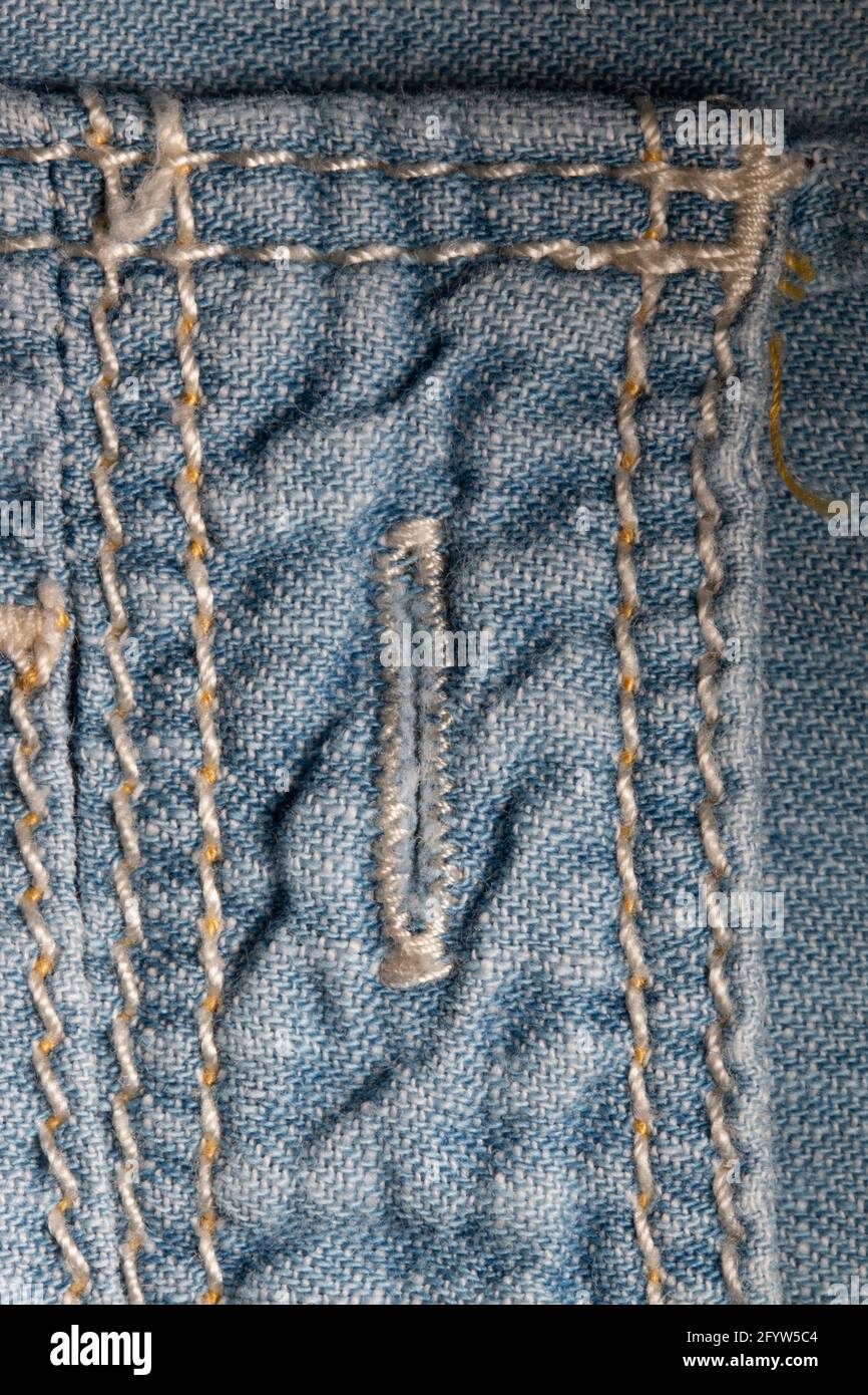 Buttonhole in a light blue denim shirt Stock Photo