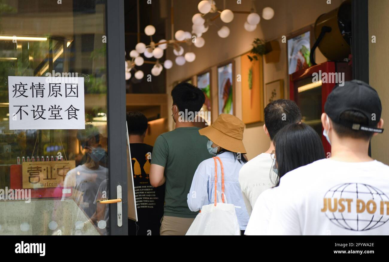 Guangzhou, China's Guangdong province. 30th May, 2021. Residents queue up to buy 'siu-mei', a kind of roasted food, at a food store in Liwan District, Guangzhou City, south China's Guangdong province, May 30, 2021. Price and supply of daily necessities are stable here amid the ongoing COVID-19 pandemic. Credit: Deng Hua/Xinhua/Alamy Live News Stock Photo