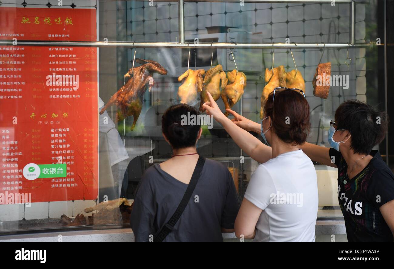 Guangzhou, China's Guangdong province. 30th May, 2021. Residents buy 'siu-mei', a kind of roasted food, at a food store in Liwan District, Guangzhou City, south China's Guangdong province, May 30, 2021. Price and supply of daily necessities are stable here amid the ongoing COVID-19 pandemic. Credit: Deng Hua/Xinhua/Alamy Live News Stock Photo