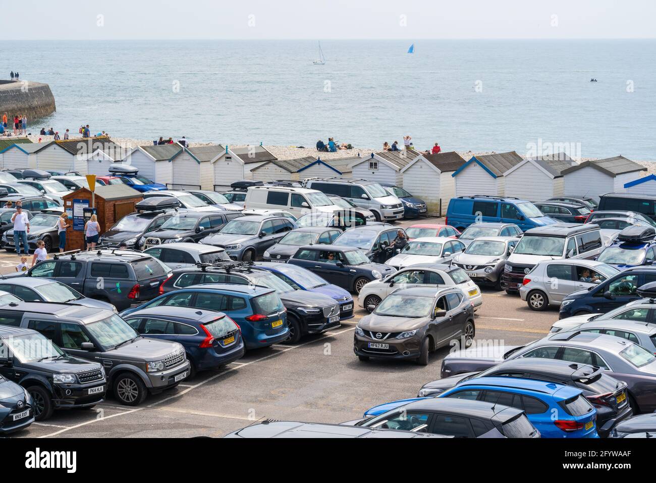 Lyme Regis, Dorset, UK. 30th May, 2021. UK Weather. Cars queued for a space in the packed Monmouth Beach car park at the seaside resort of Lyme Regis on the bank holiday weekend as people flocked to the beach to enjoy scorching hot sunsine as the heatwave continues. Credit: Celia McMahon/Alamy Live News Stock Photo