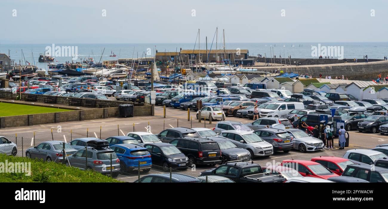 Lyme Regis, Dorset, UK. 30th May, 2021. UK Weather. Cars queued for a space in the packed Monmouth Beach car park at the seaside resort of Lyme Regis on the bank holiday weekend as people flocked to the beach to enjoy scorching hot sunsine as the heatwave continues. Credit: Celia McMahon/Alamy Live News Stock Photo