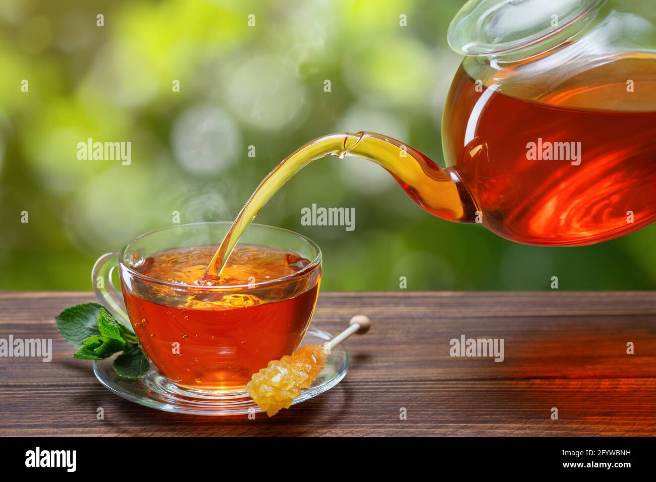 tea with mint pouring from teapot into cup Stock Photo