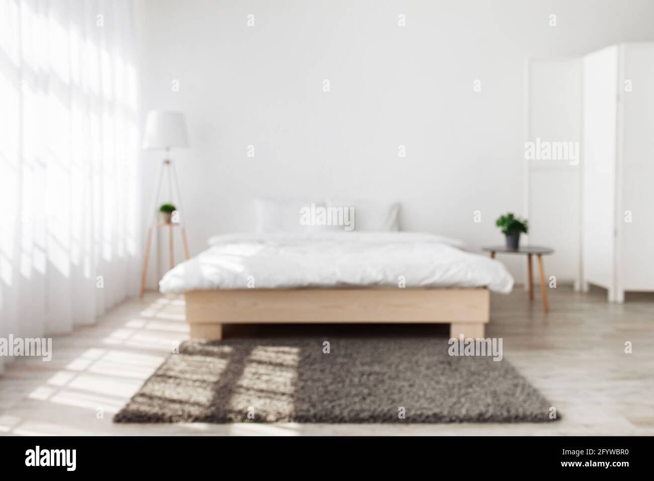 Stylish light minimalist design in daylight in bedroom interior Stock Photo