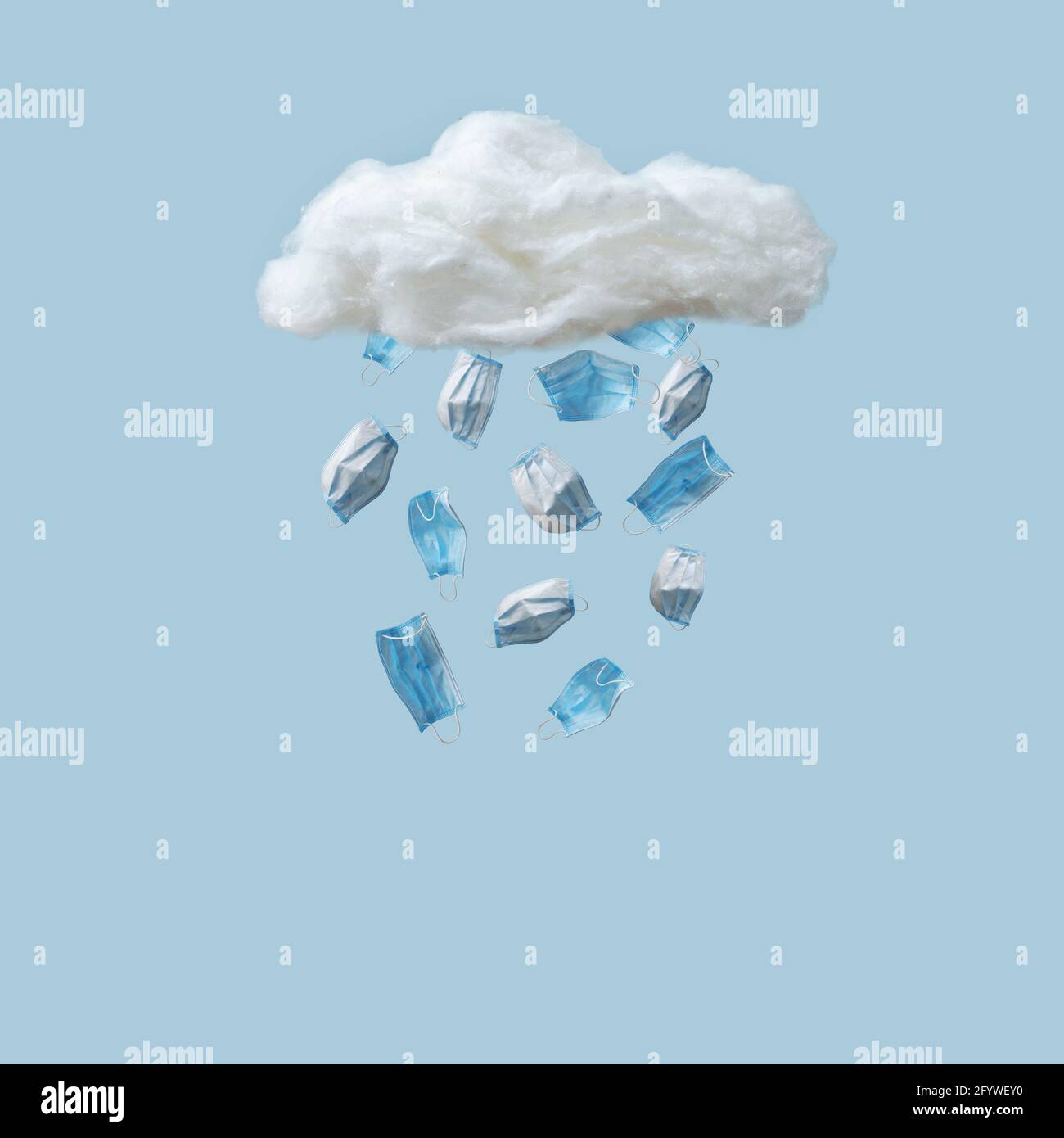 Protective medical masks fall in the form of precipitation from the sky from a cloud. A minimal concept of health protection in the face of the new no Stock Photo