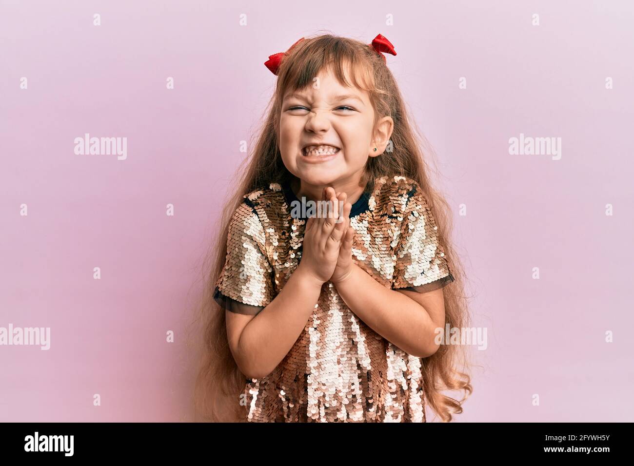Little caucasian girl kid wearing festive sequins dress praying with ...