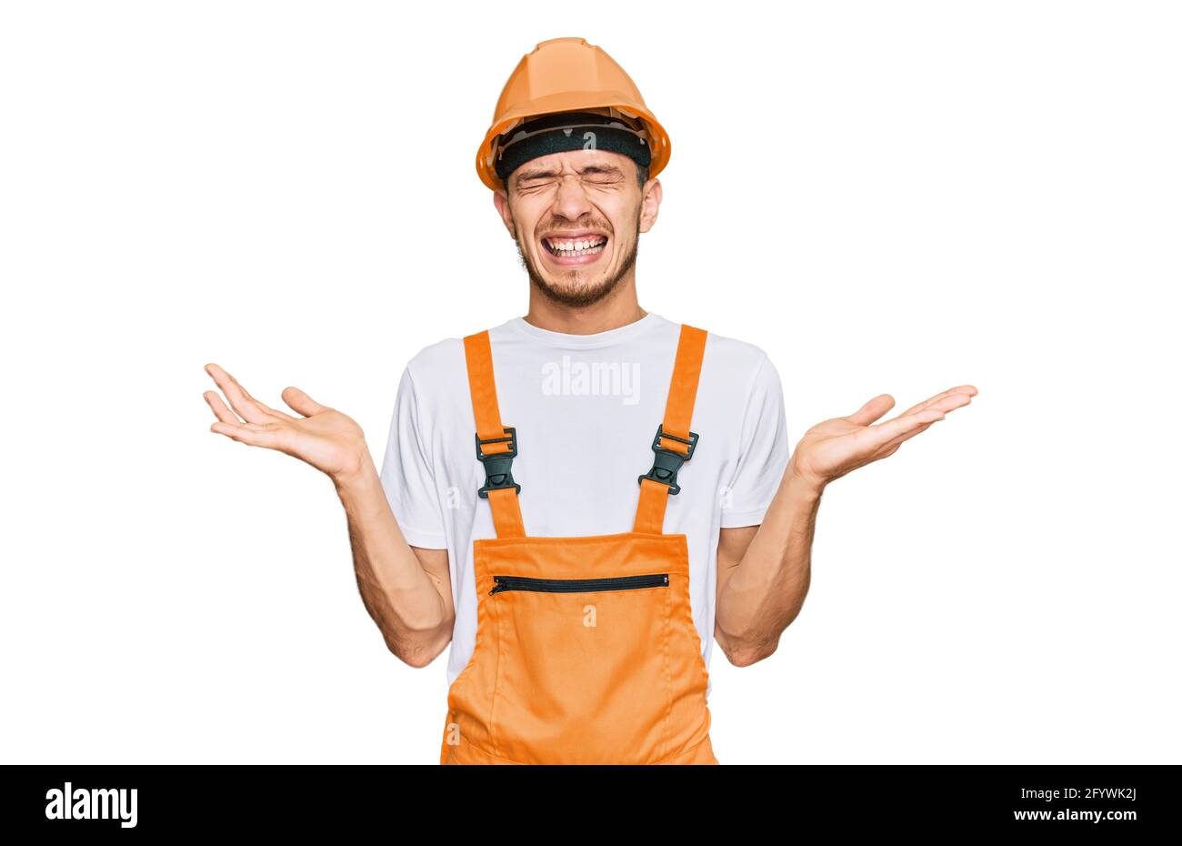 Hispanic young man wearing handyman uniform and safety hardhat ...
