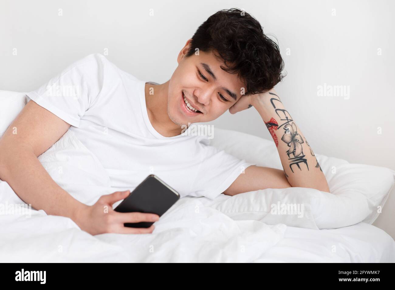 Weekend, free time, wake up with device in positive mood at home Stock Photo