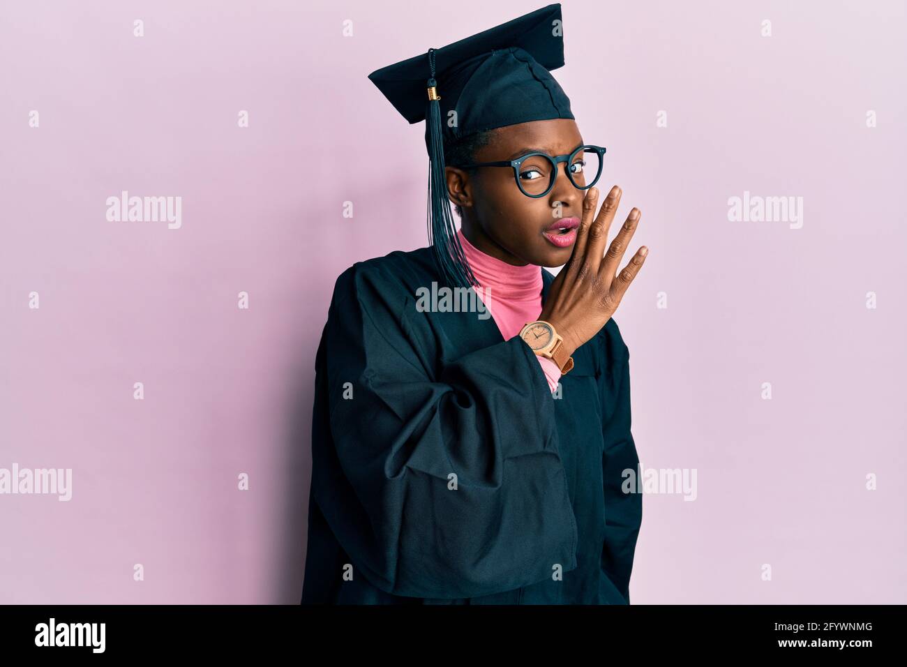 Young african american girl wearing graduation cap and ceremony robe ...