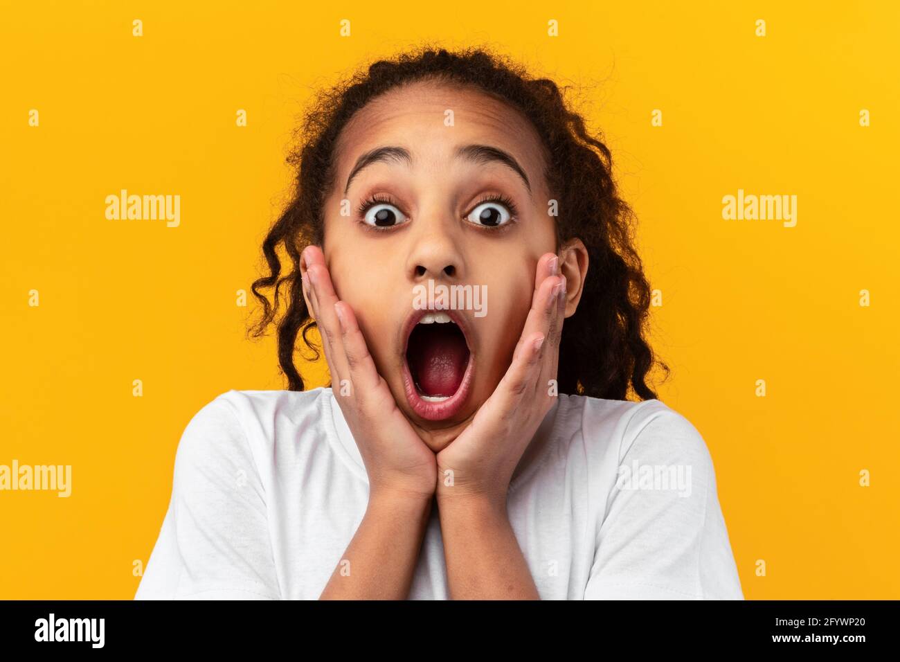Wow. Excited black girl touching her cheeks Stock Photo