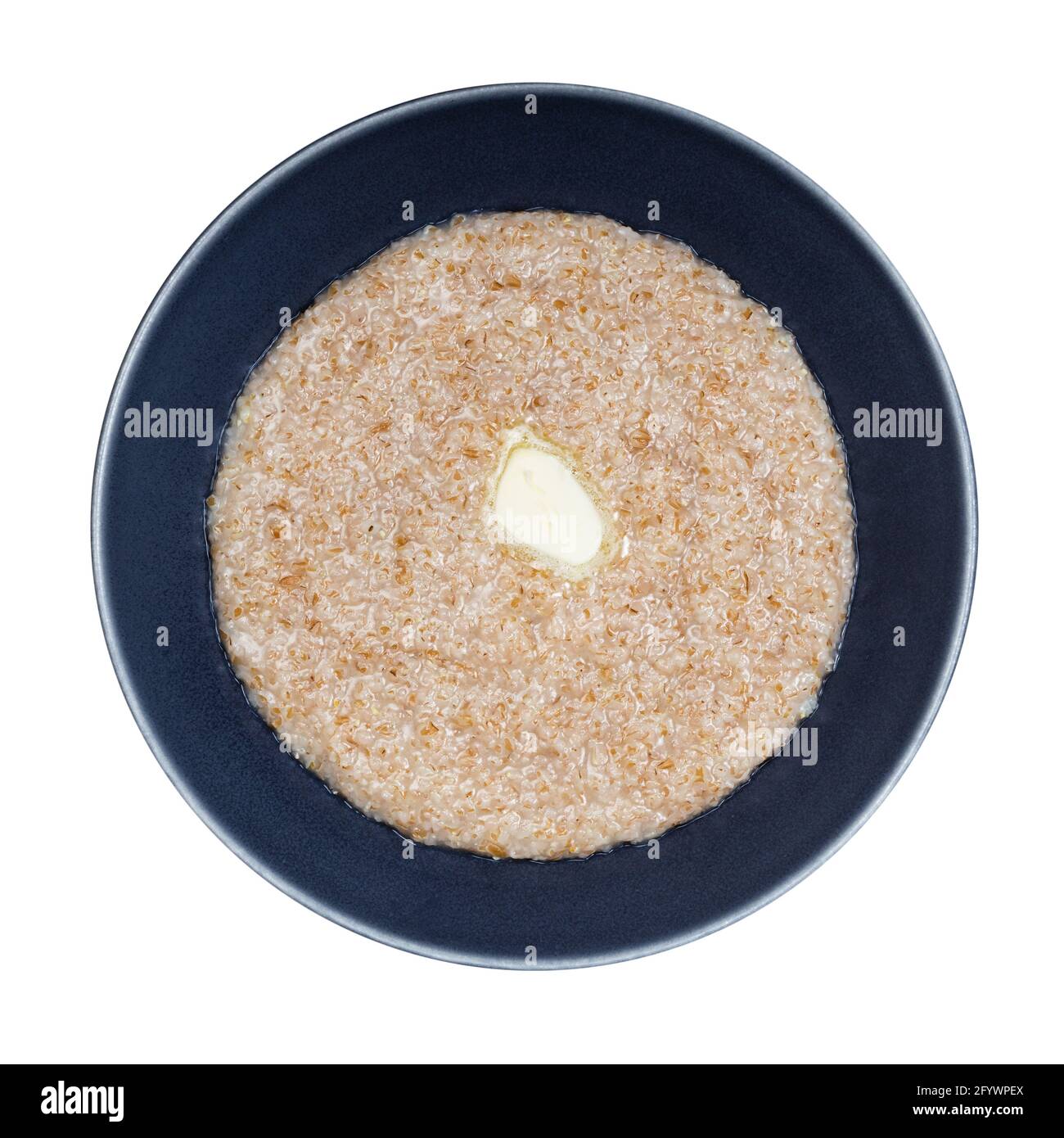 top view of buttered porridge from wheat groats (crushed partly hulled wheat grains) in gray bowl isolated on white background Stock Photo