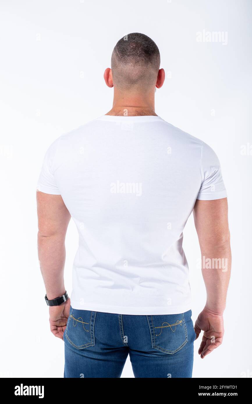 Rear view of a man standing while wearing a white t-shirt and a pair of ...