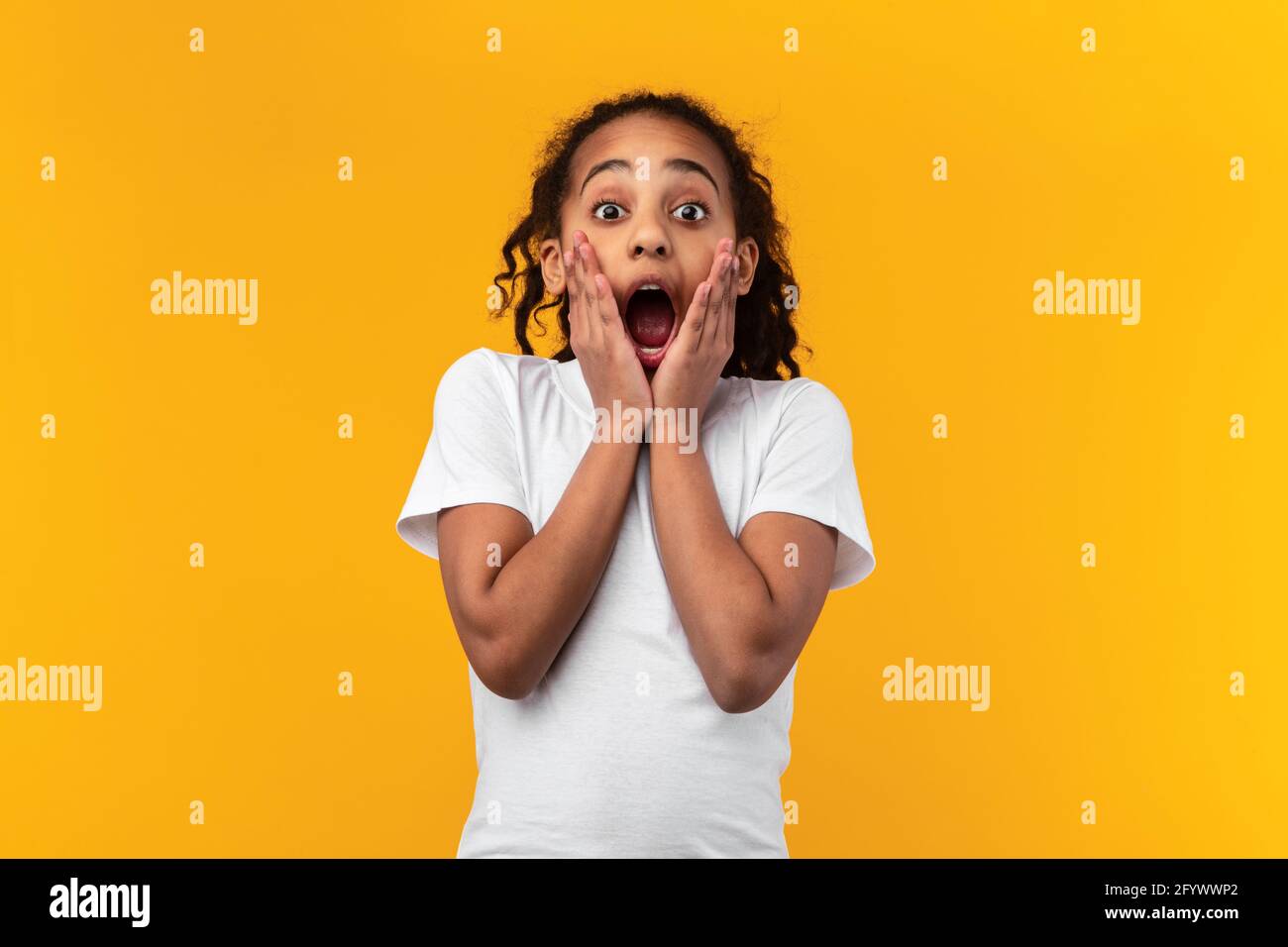 Wow. Excited black girl touching her face Stock Photo