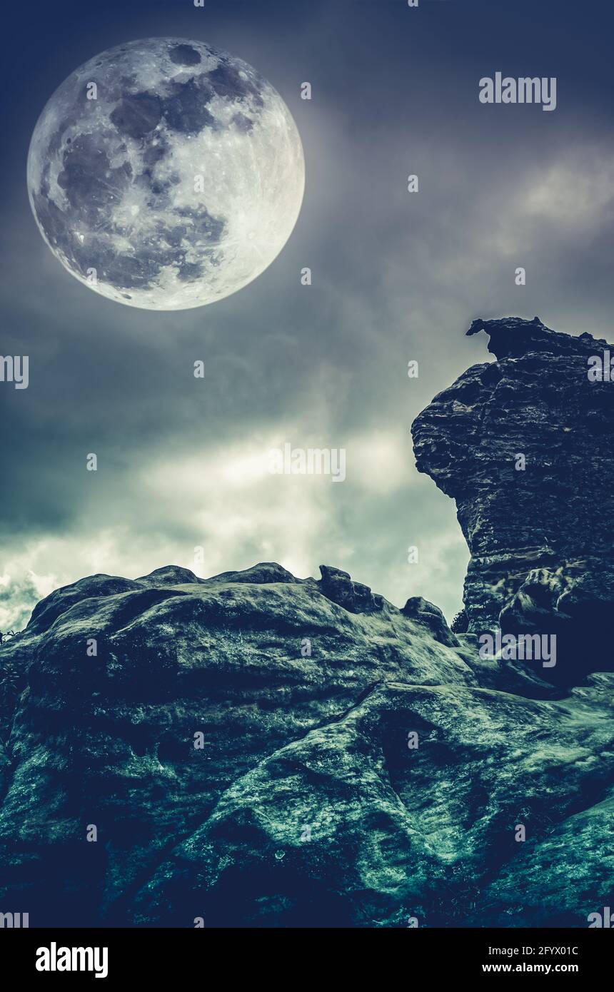 Boulder with sky background and beautiful full moon behind cloud at night.  Outdoor at nighttime. Beauty of nature use as background. Cross process sty  Stock Photo - Alamy