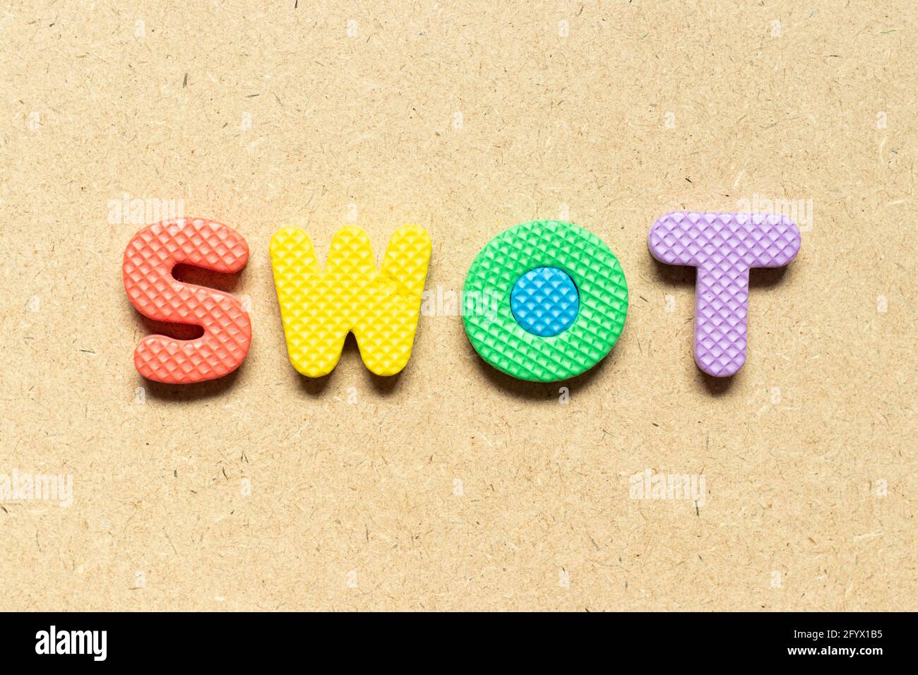 Foam alphabet letter in word SWOT (abbreviation of strength, weakness, opportunities, threats) on wood background Stock Photo