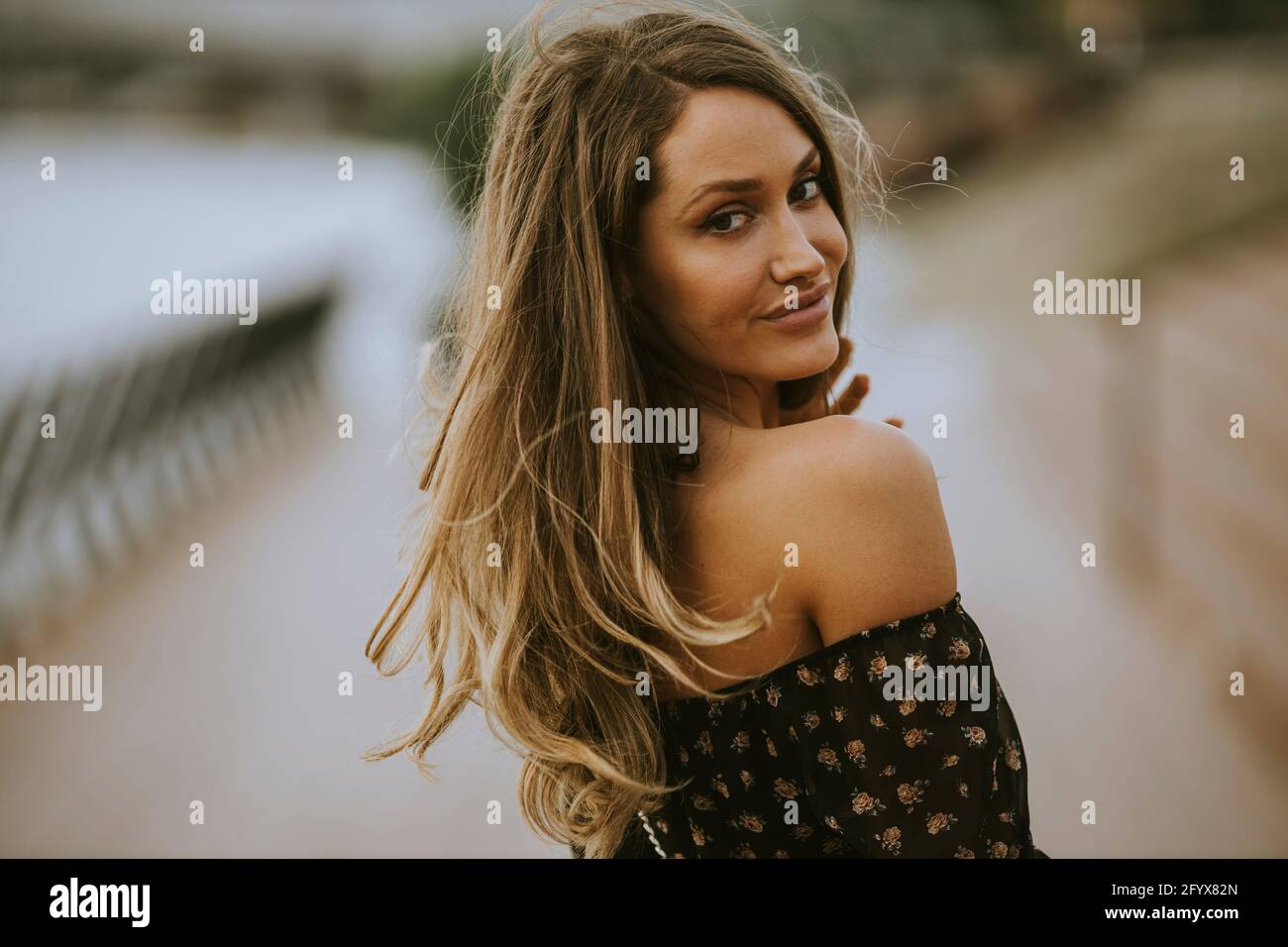 Pretty young long hair brunette woman walking on the riverside Stock ...