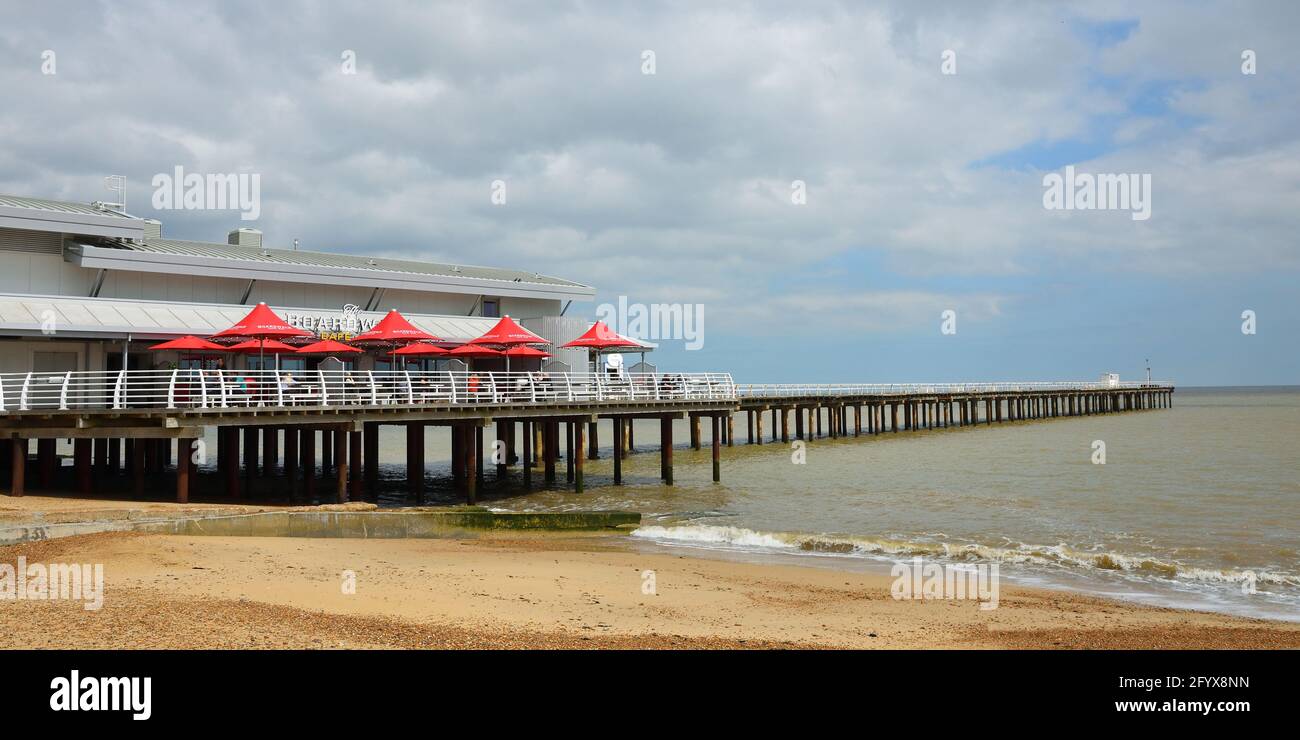 Felixstowe Pier beach and sea with red parasols. Stock Photo