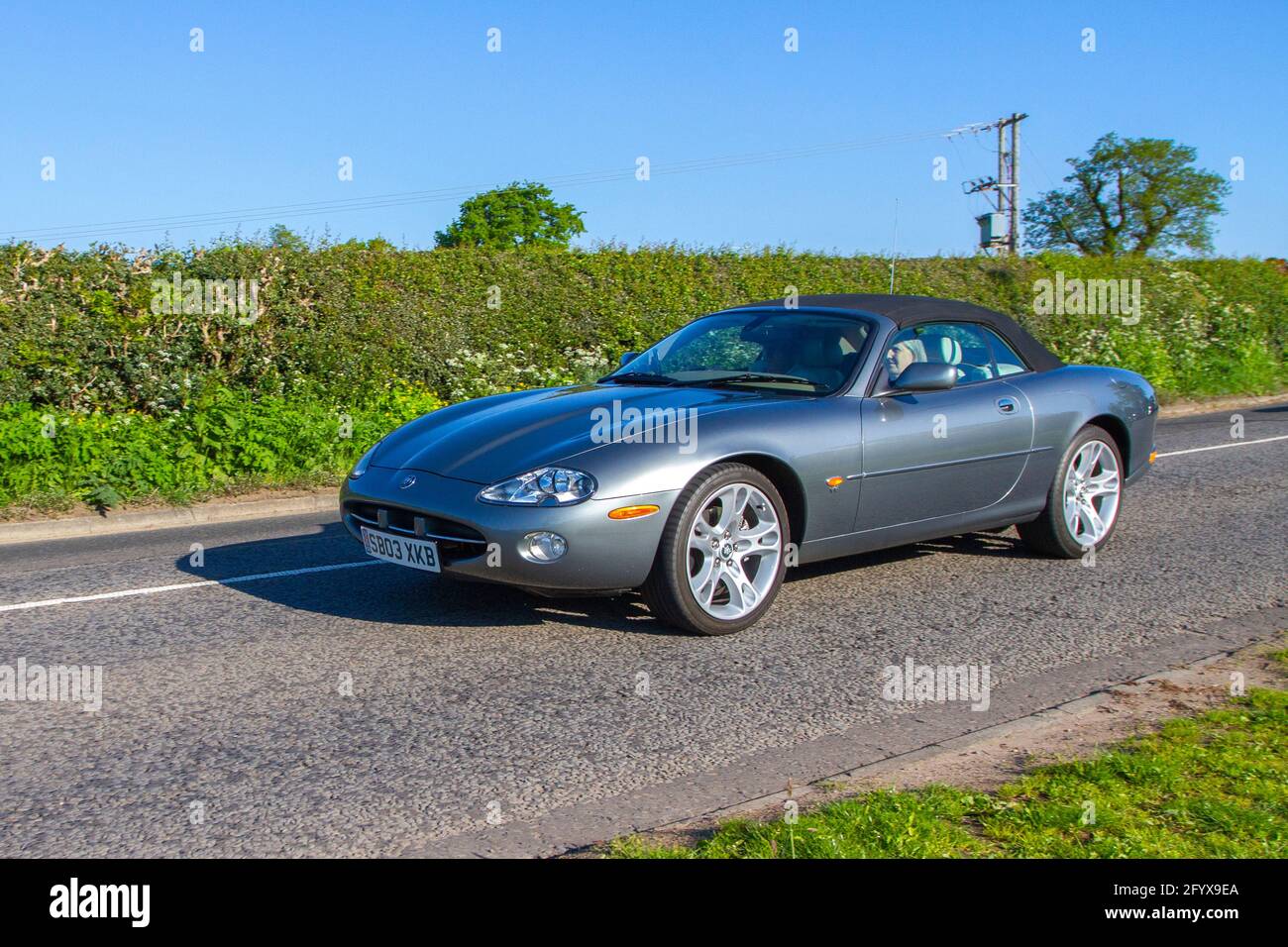 2003 grey Jaguar Xk8 Convertible 4196cc convertible Auto; Vehicular traffic, moving vehicles, cars, vehicle driving on UK roads, motors, motoring  en-route to Capesthorne Hall classic May car show, Cheshire, UK Stock Photo