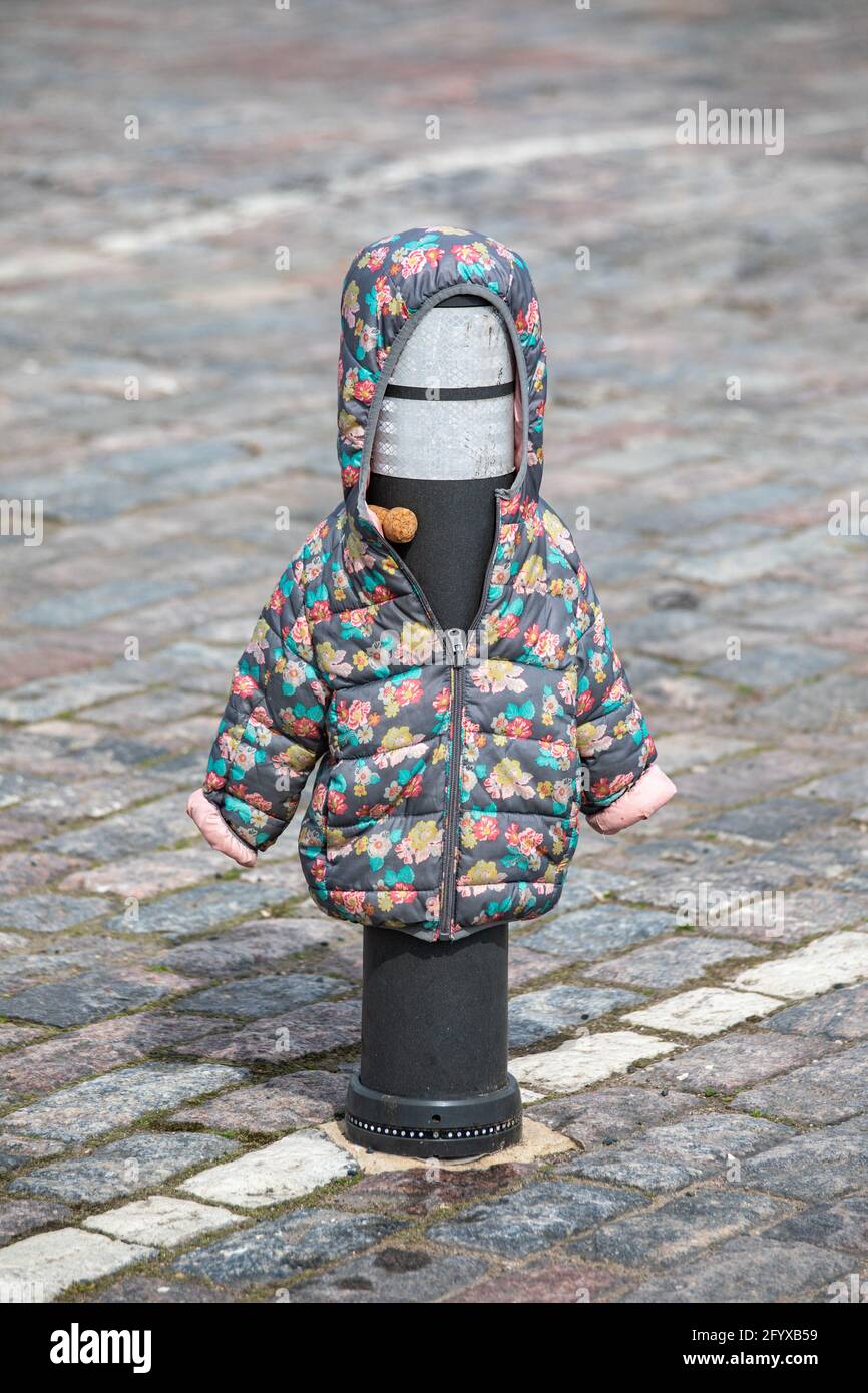 Lost child's winter jacket or coat on traffic bollard Stock Photo