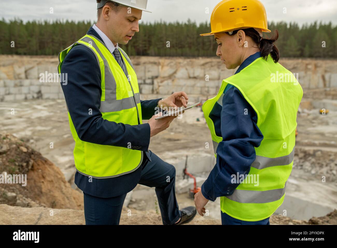 Contractor in hardhat consulting builder and using tablet Stock Photo