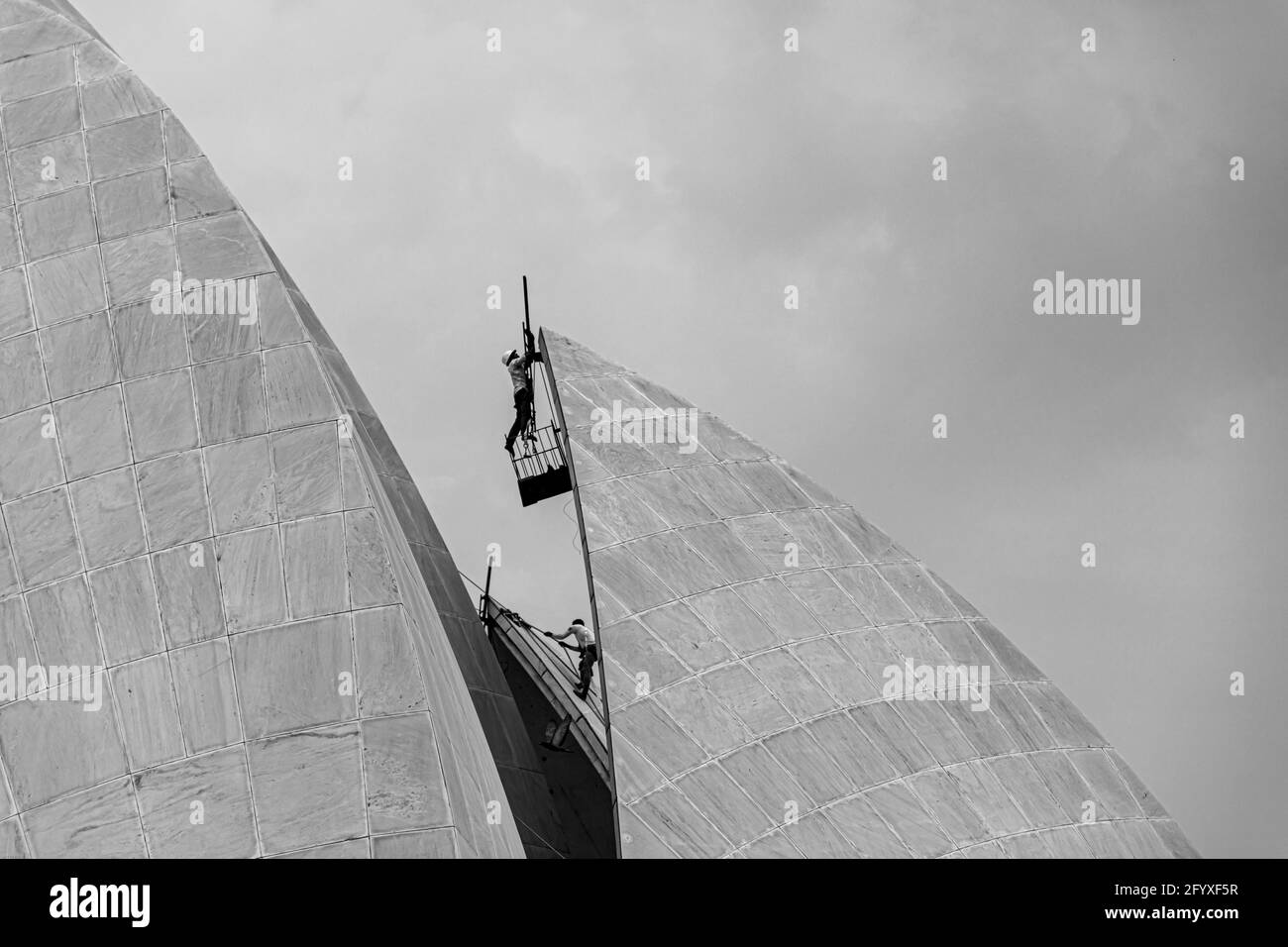 black and white picture of a labor is working at bahai lotus temple,new delhi, india. Stock Photo