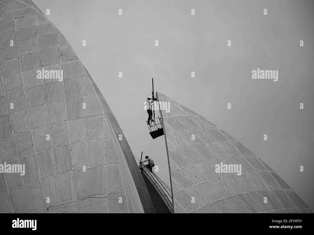 black and white picture of a labor is working at bahai lotus temple,new delhi, india. Stock Photo