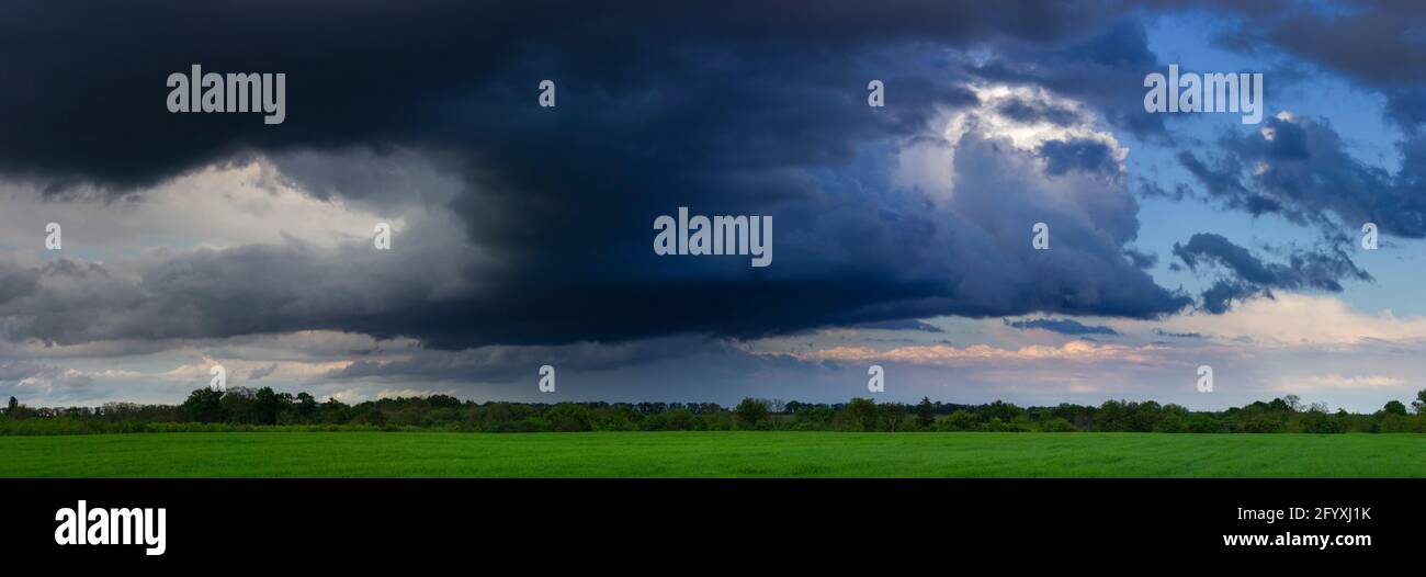 Dramatic clouds, field and sky with dark clouds Stock Photo