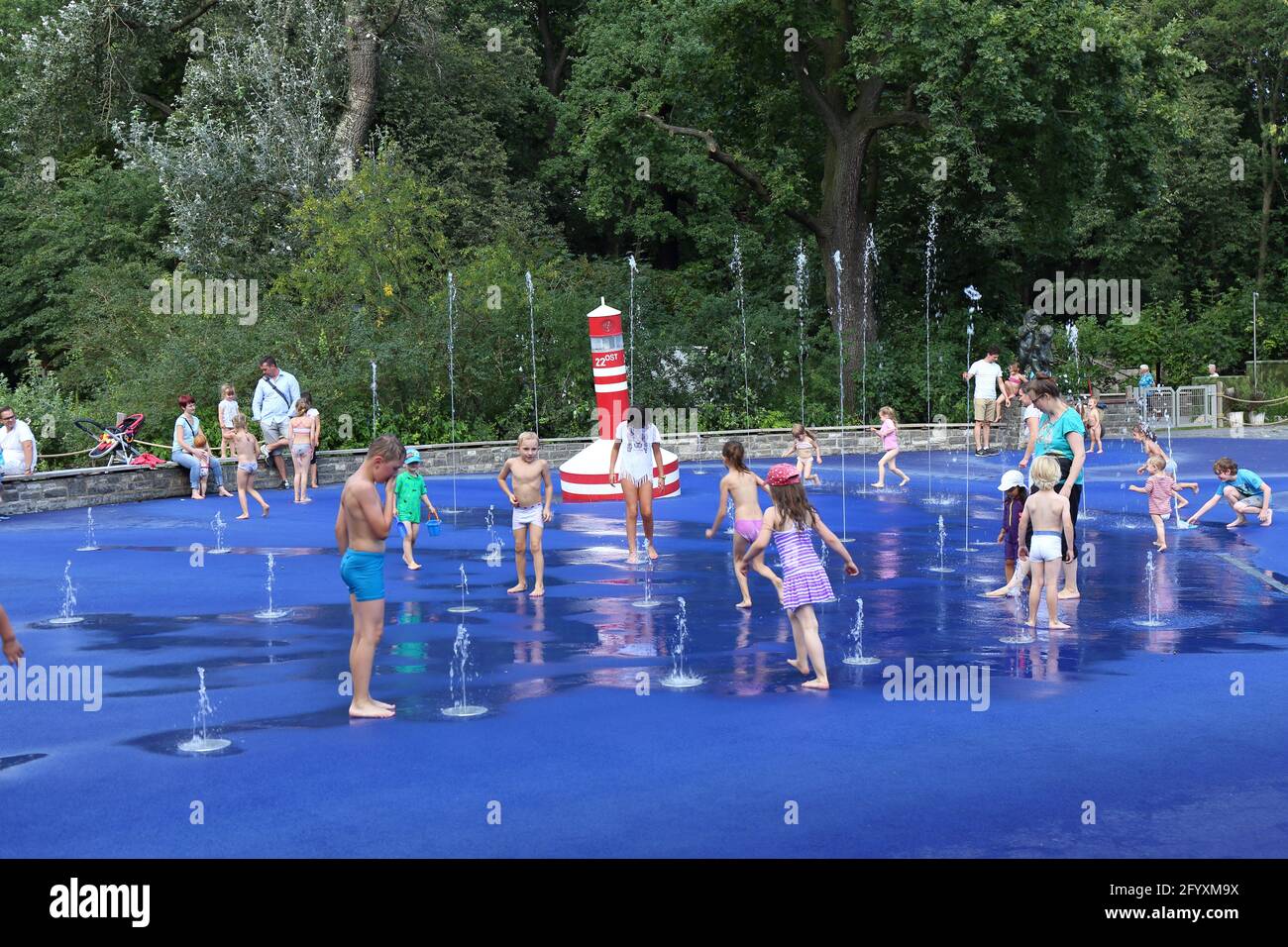 little kids enjoy the sunny day and playing with the water at the water playground Stock Photo