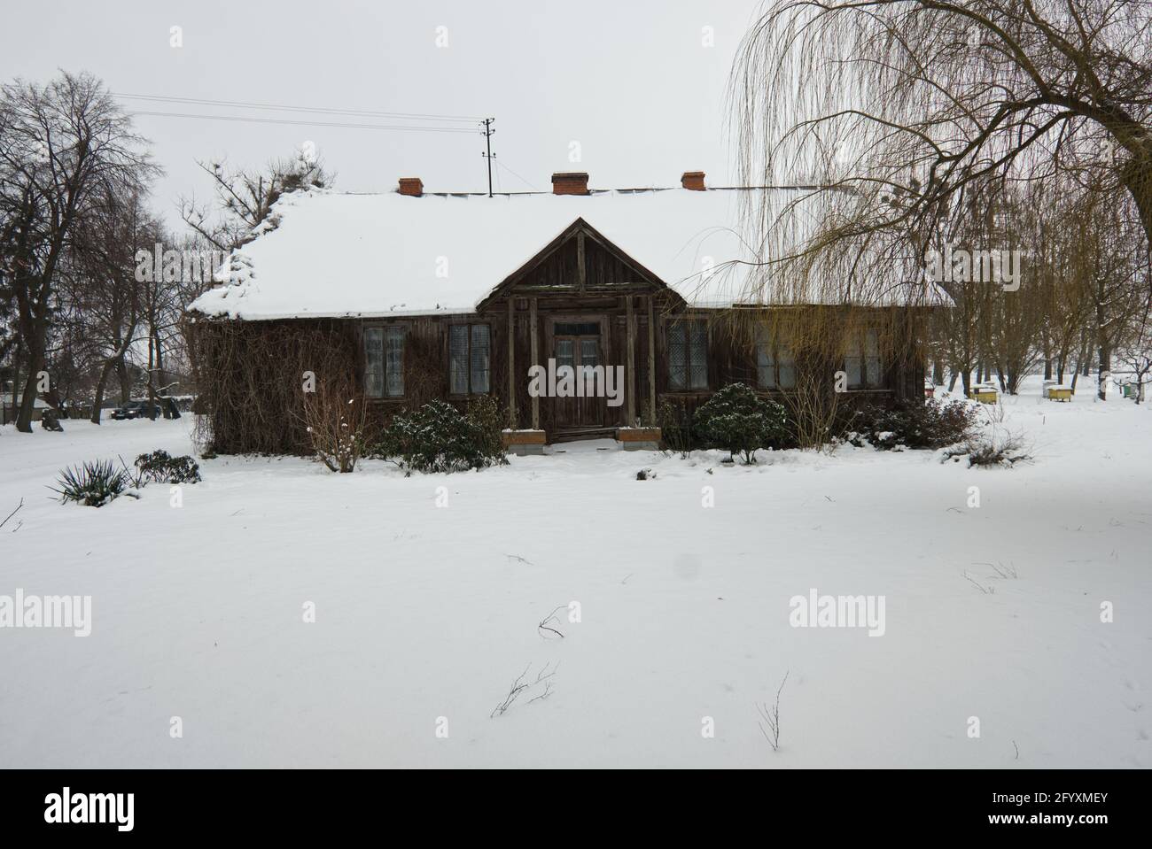 DRATOW, POLAND 01/29/21 Old wooden building of a rectory covered in snow in winter Stock Photo